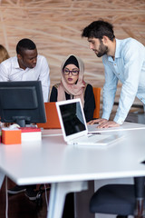 diverse college students using laptop and talking, learning exchanging ideas