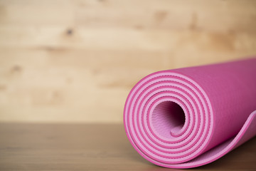 close up of pink yoga mat on the table, sport and healthy concept