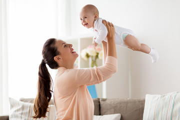 happy mother playing with little baby boy at home