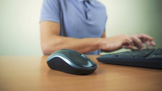 Close up of hands typing on computer keyboard and mouse