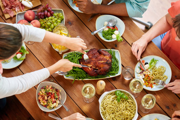 group of people eating chicken for dinner © Syda Productions