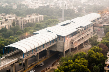 Under construction over head metro station over a busy street in Delhi Noida. Shot on a foggy...