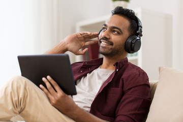 man in phones with tablet pc listening to music