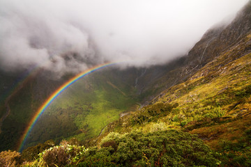 Rainbow over the valley between Mintaro Hutt and Mackinnon Pass, Milford Track Fiordland National...