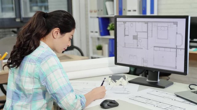 female designer check the blueprint