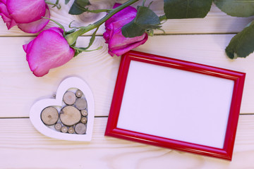 Pink roses on wooden background