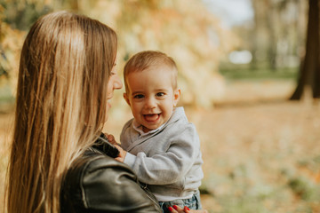 Young mother and baby boy in autumn park