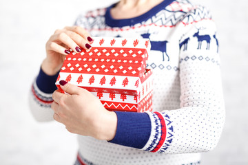 Christmas gift box in female hand on white background