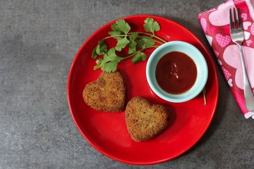 Heart shaped Cutlets in red plate with sauce and cilantro / Valentines day food