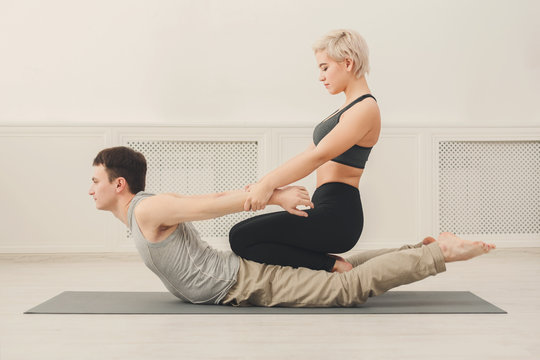 Young man with yoga instructor in fitness club
