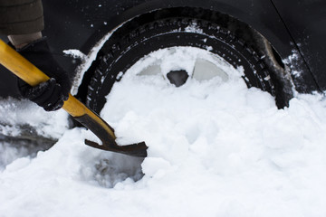  a man cleaning a car from a snow shovel