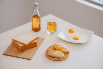 Morning breakfast with glass of tea, toast, fried eggs and bread on table