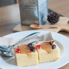 Fruit cake in white plate on vintage wooden table.