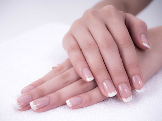 Naklejka premium Close up of beautiful Woman Hands. Spa and Manicure concept. Female hands with french manicure. Soft skin, skincare concept. Beauty nails. over beige background