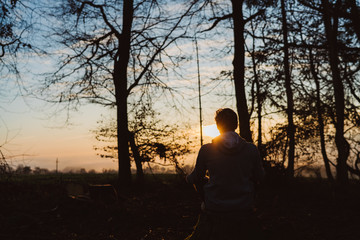 Fototapeta na wymiar Young man meditating at sunrise in a forrest in Austria