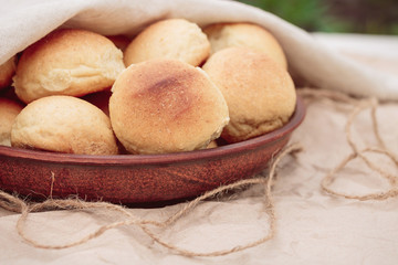 Homemade freshly baked buns in a clay plate. Delicious bread
