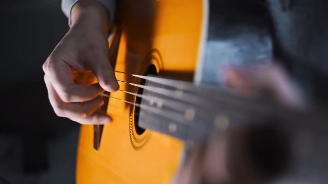 Guitar player plays scales and gamms on the acoustic western guitar with steel strings by finger picking technique, exercises and arpeggios, video with sound, plaing the guitar