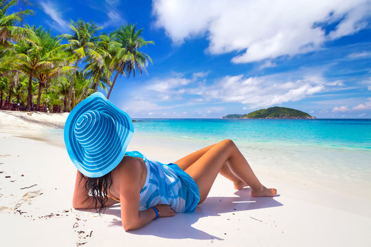 Beautiful woman in blue hat on the tropical beach