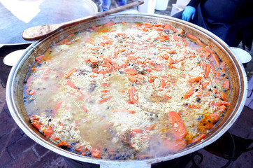 Pilaf is cooked on the grill in a large cauldron. 