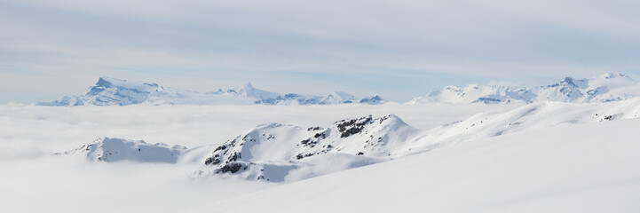 Fototapeta na wymiar Panorama dans les Alpes enneigés et avec la mer de nuages