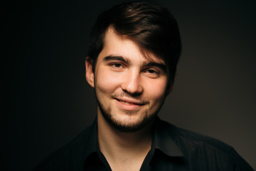 young brunette guy on a dark background