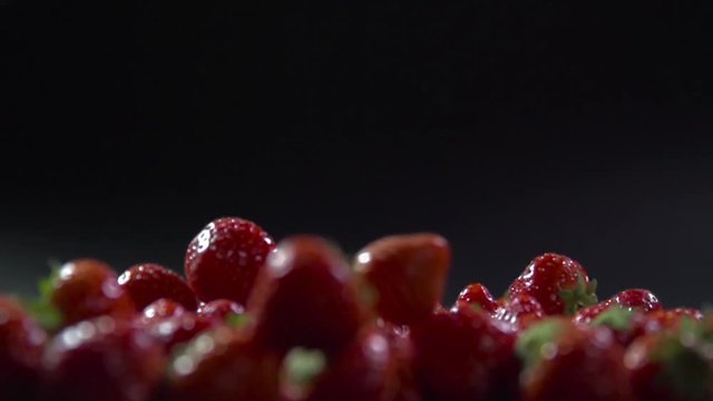 Several berries fall on the strawberry.