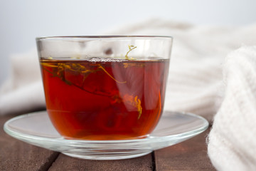 The amber Cup of tea on a brown wooden surface