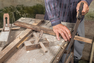Hands of a carpenter planed wood, workplace 