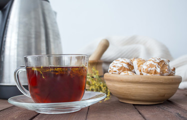 Cup of tea with biscuits and a kettle in the background