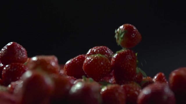 Berries fall on a layer of strawberry.