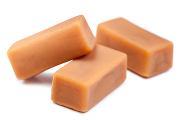 Delicious caramel candies chunks  isolated on white background  with copy space, macro.