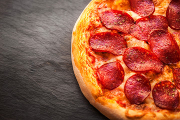 Hot Homemade Pepperoni Pizza Ready to Eat on black background.