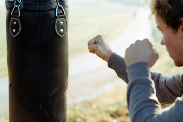 Young athlete boxing the punching bag outside in Austria