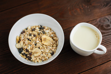 Top view of cereal breakfast with dried banana and raisins. Healthy vegetarian snack.