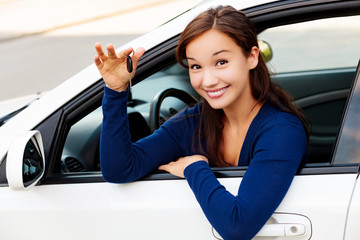 Happy female driver showing car key