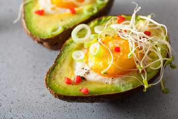 egg baked in avocado with spring onion and alfalfa sprouts