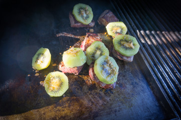 Cooking on BBQ kiwifruit on lamb.
