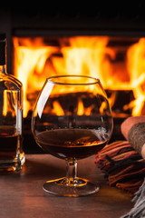 a glass of cognac in front of fireplace