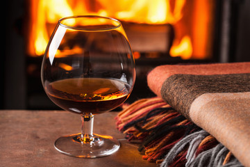 a glass of cognac in front of fireplace
