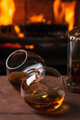 a glass of cognac in front of fireplace
