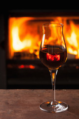 a glass of cognac in front of fireplace