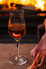 a glass of cognac in front of fireplace