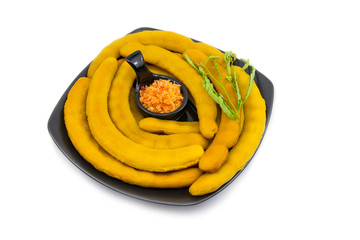 Pickled tamarind preserved in syrup on dish a black ceramic plate It is on isolated a white...