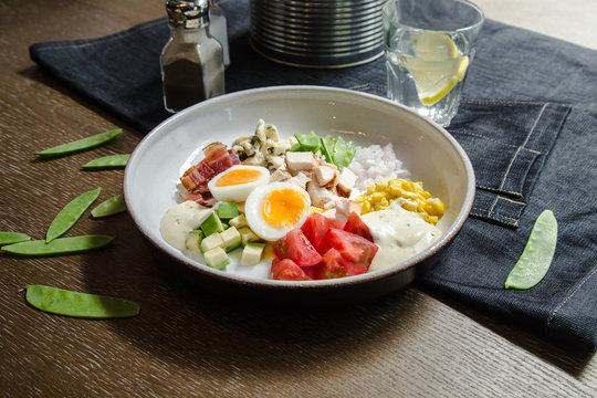 Healthy Hearty Cobb Salad with Chicken, Bacon, Tomato, Onions, Eggs, green beans. American food. Close up, home made