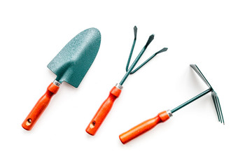 Gardening tools: spade, fork, hand cultivator, hoe on white background top view