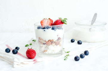 Healthy breakfast of homemade granola cereal with strawberry, nuts and fruit, honey with drizzlier background. Morning food, Diet, Detox, Clean Eating, Vegetarian concept.