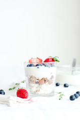 Healthy breakfast of homemade granola cereal with strawberry, nuts and fruit, honey with drizzlier background. Morning food, Diet, Detox, Clean Eating, Vegetarian concept.