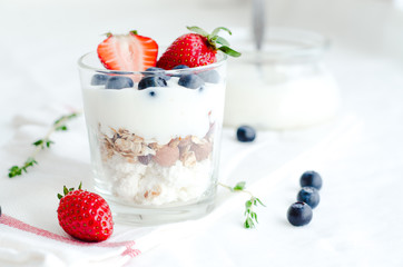 Healthy breakfast of homemade granola cereal with strawberry, nuts and fruit, honey with drizzlier background. Morning food, Diet, Detox, Clean Eating, Vegetarian concept.