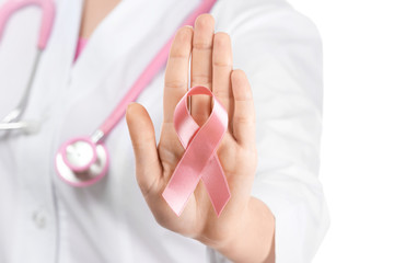 Doctor showing pink ribbon on white background. Breast cancer awareness concept