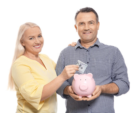 Mature couple with piggy bank on white background